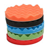 A stack of five colored foam polishing pads for car detailing, including orange, black, blue, green, and red.