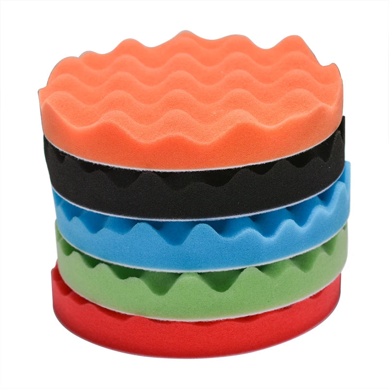 A stack of five colored foam polishing pads for car detailing, including orange, black, blue, green, and red.