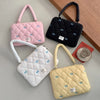 Three quilted laptop shoulder bags in pink, black, and beige with blue bows are displayed on a light surface.