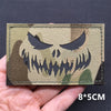 A close-up of a tactical patch featuring a menacing skull design on a camouflage background.