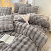 A gray ultra-soft plush 4-piece bedding set featuring textured, fluffy fabric pillows and a blanket.