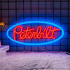 A bright red Peterbilt truck neon sign is displayed against a dark blue tiled wall.