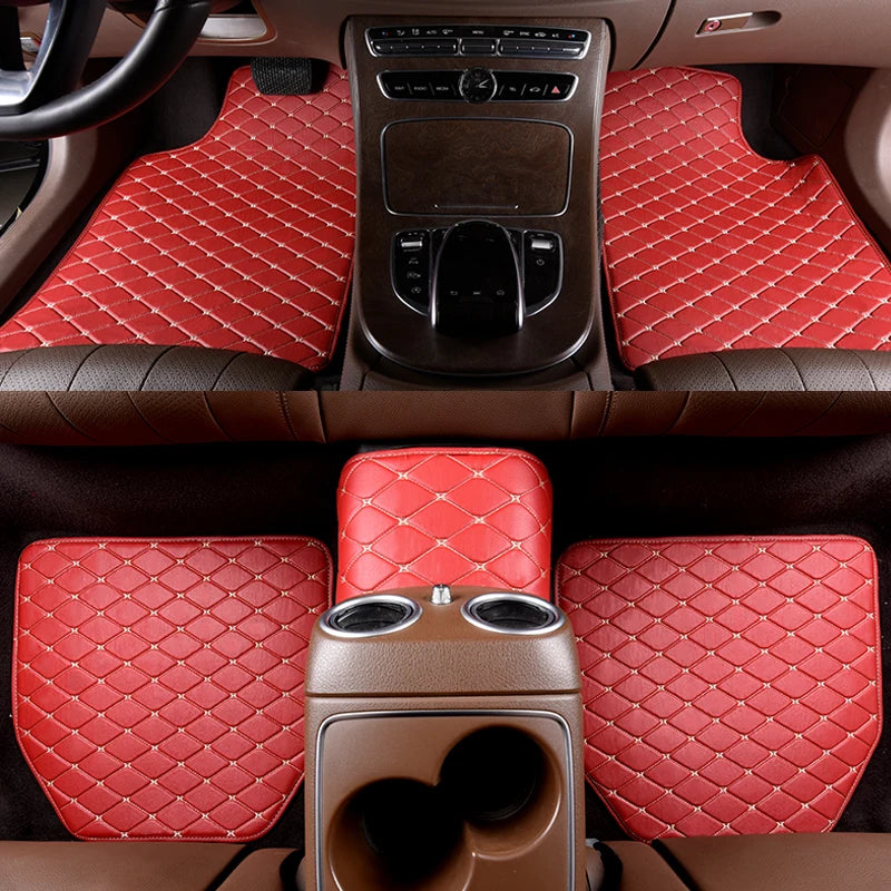 Interior view of a car showing red quilted leather floor mats and a center console with controls.