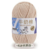 A skein of light beige milk cotton blend yarn is shown, packaged with a label featuring Chinese and English text.