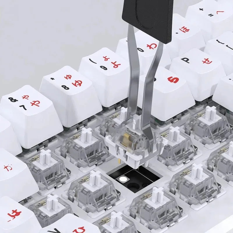 A close-up view of a mechanical keyboard keycap puller and adjuster tool with various keycaps visible.