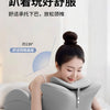 A woman is using a gray ergonomic memory foam wedge pillow for prone sleeping or reading.