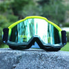 A pair of lime green and black retro motorcycle sunglasses resting on a gray rock.