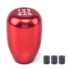 A shiny red aluminum gear shift knob with markings 135 HH 24A and three accompanying adapters.