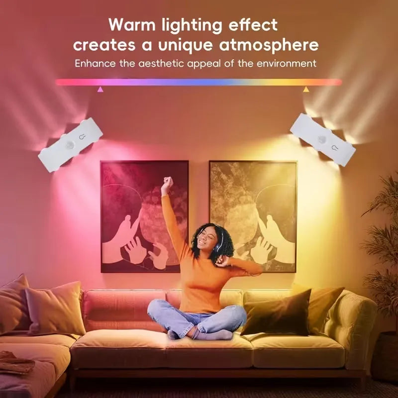 A person sitting on a sofa is illuminated by warm lighting from smart motion-sensor LED wall lights.