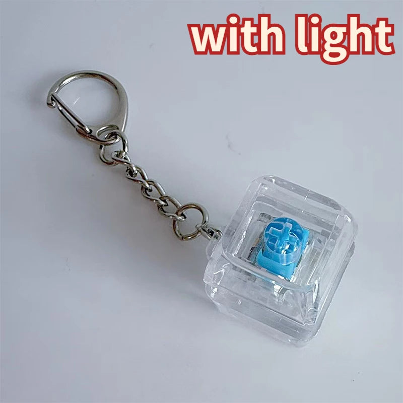 A clear plastic LED mechanical keychain fidget toy with a blue keycap and silver chain.