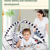 A woman is demonstrating a multi-faceted training of baby's motor ability and intellectual development using a play gym mat w