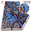 A bolt of pink glitter African wax print fabric featuring intricate floral patterns and blue accents.