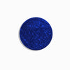 A dark blue, round coaster with a textured diamond pattern.