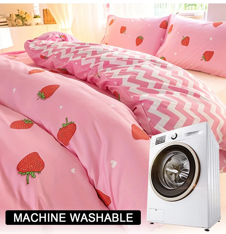 Pink strawberry print duvet cover set and pillowcases displayed on a bed next to a white washing machine.