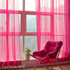 Pink sheer voile curtains with a rod pocket filtering light in a bright room.