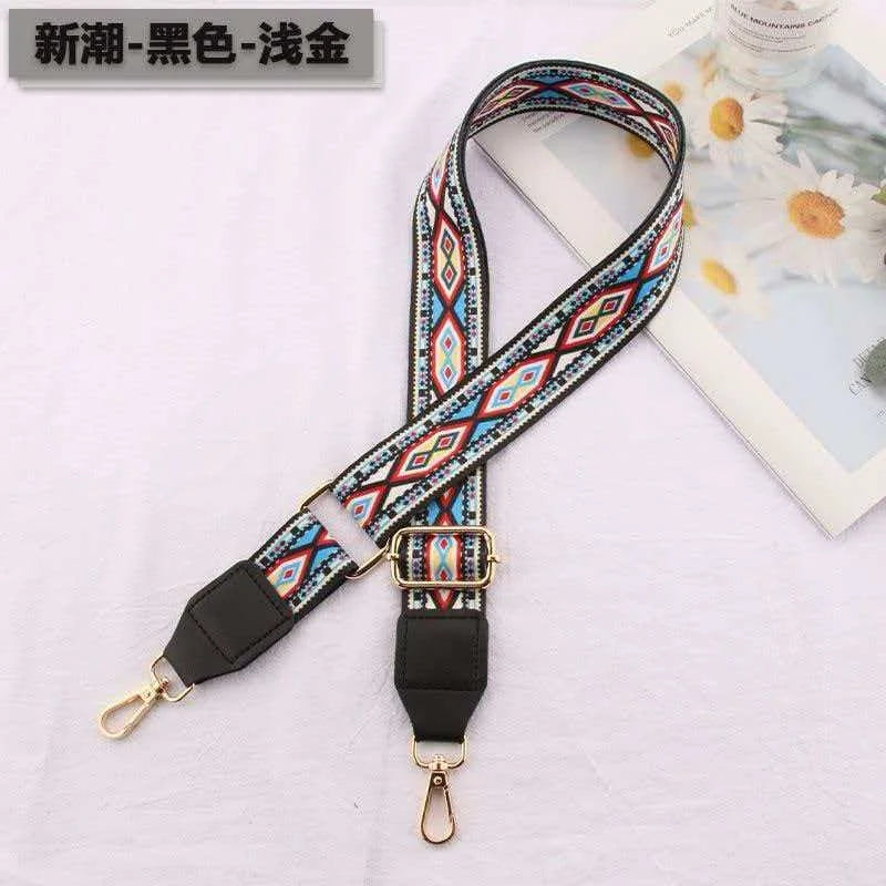 A black, gold, and blue patterned leather strap for an adjustable crossbody bag.