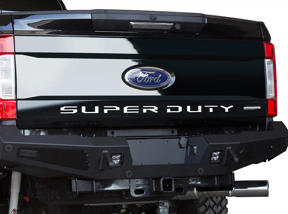 Rear view of a black Ford Super Duty truck tailgate with the Ford emblem and Super Duty lettering.