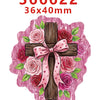 A wooden cross decorated with pink and red roses and leaves, set against a light pink background.