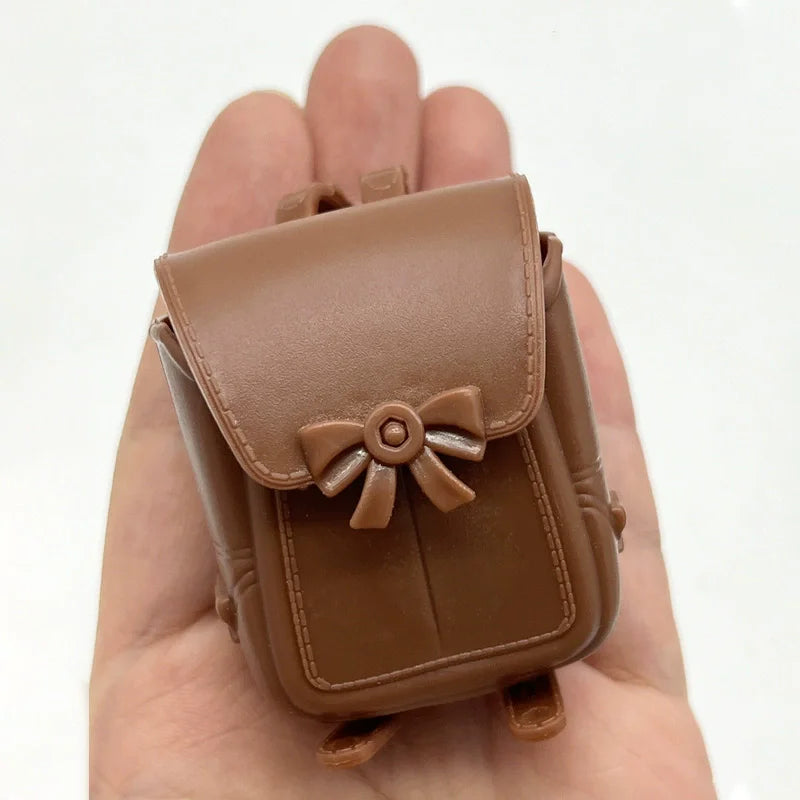A brown leather pouch with a bow is held in a person's hand.