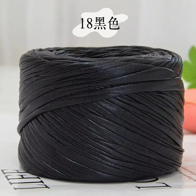 A ball of black metallic flat ribbon yarn for crochet and knitting.