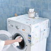 A white washing machine is covered with a light blue cloth, displaying various cleaning supplies on top.
