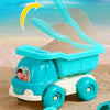 A blue toy vehicle carrying a light gray sand shovel, set in a sandy environment.