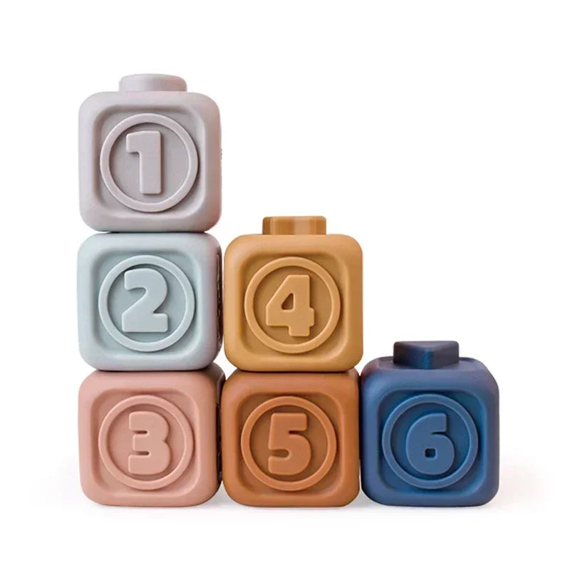 Six soft silicone building blocks numbered 1 through 6 in pastel and earthy tones.