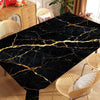 Black gold marble waterproof tablecloth displayed on a dining table with wicker chairs.