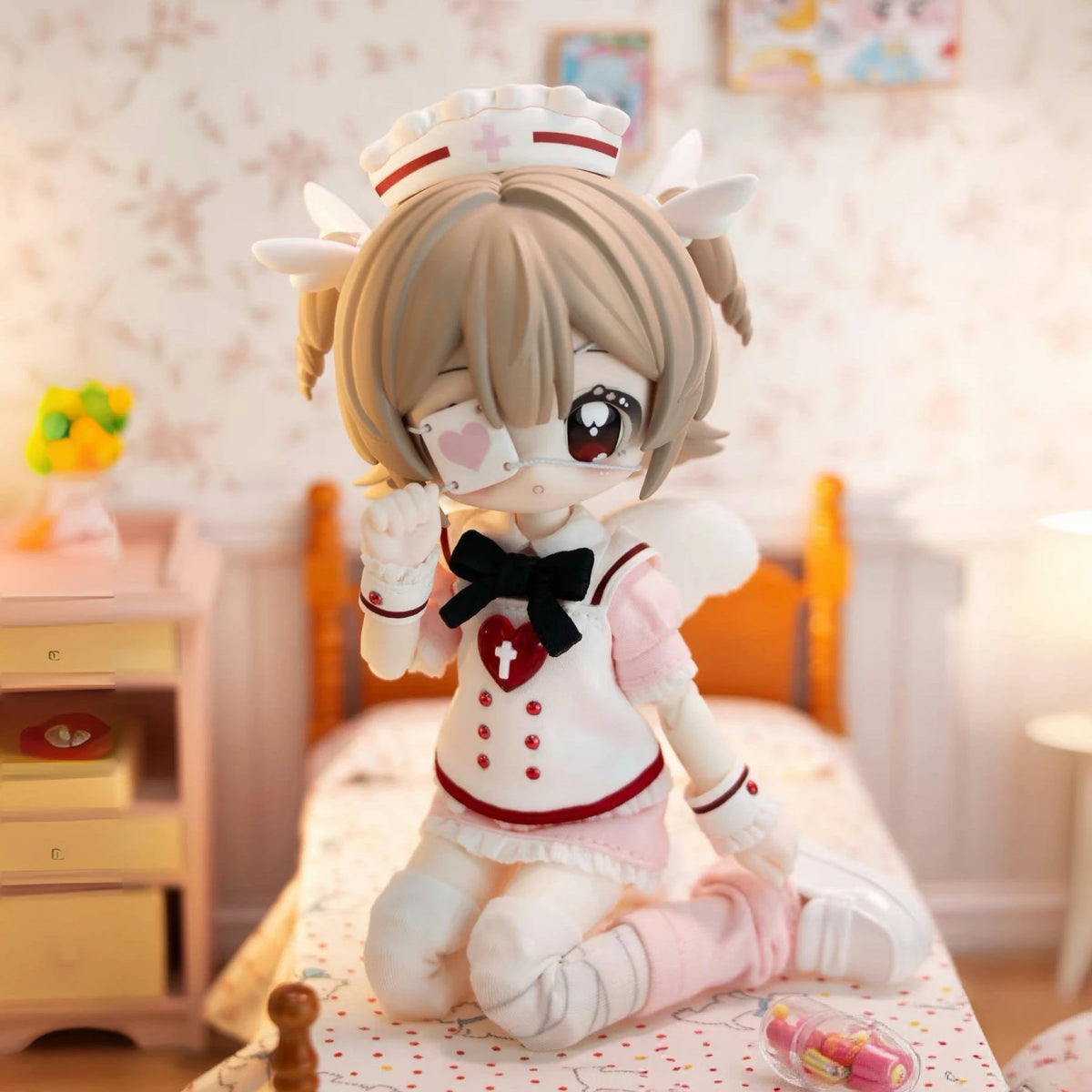 A cute, light brown-haired BJD collectible figurine with pink accents sitting on a bed.