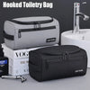 A gray hooked toiletry bag and a black hooked toiletry bag are shown next to a bathroom sink and a toothbrush.