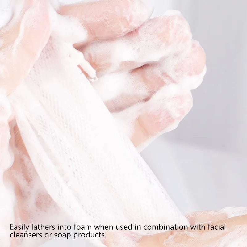 Hands lathering white foam from soap net bags used with facial cleansers or soap products.