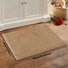 A rectangular beige faux sisal non-slip kitchen runner rug placed on a wooden floor.
