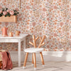 A vintage floral peel-and-stick wallpaper featuring soft pink and green botanical patterns on a wall.