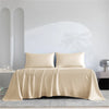 Luxuriöses Bambus-Bettlaken-Set in Beige über einem Bett mit weißen Wänden drapiert.