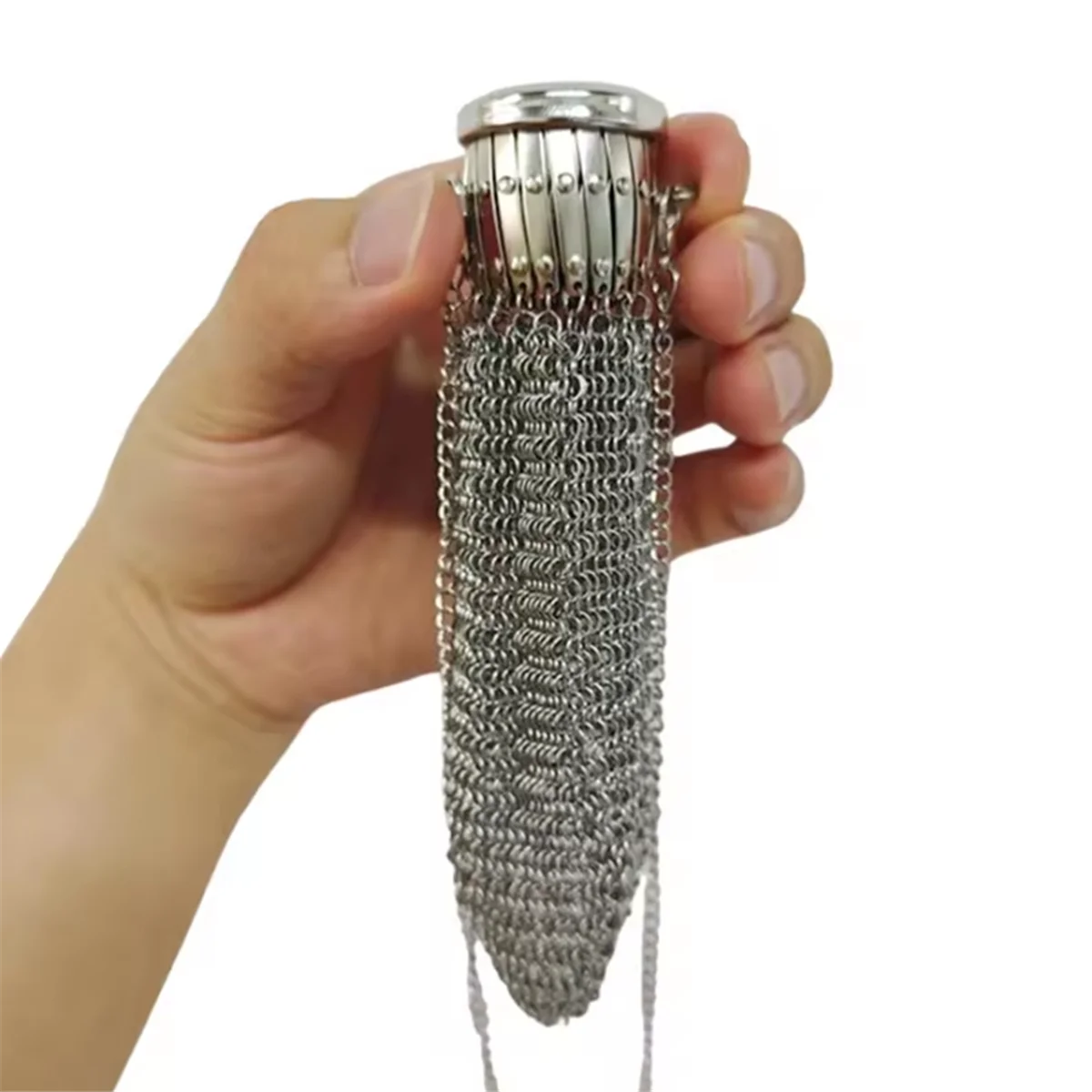 A hand holds a handcrafted stainless steel coin purse with a textured chain design.