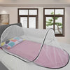 A pink instant pop-up mosquito net is draped over a single bed for portable protection.