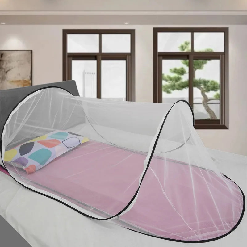 A pink instant pop-up mosquito net is draped over a single bed for portable protection.