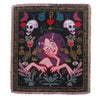 A dark woven blanket featuring a stylized female face surrounded by floral and decorative motifs.