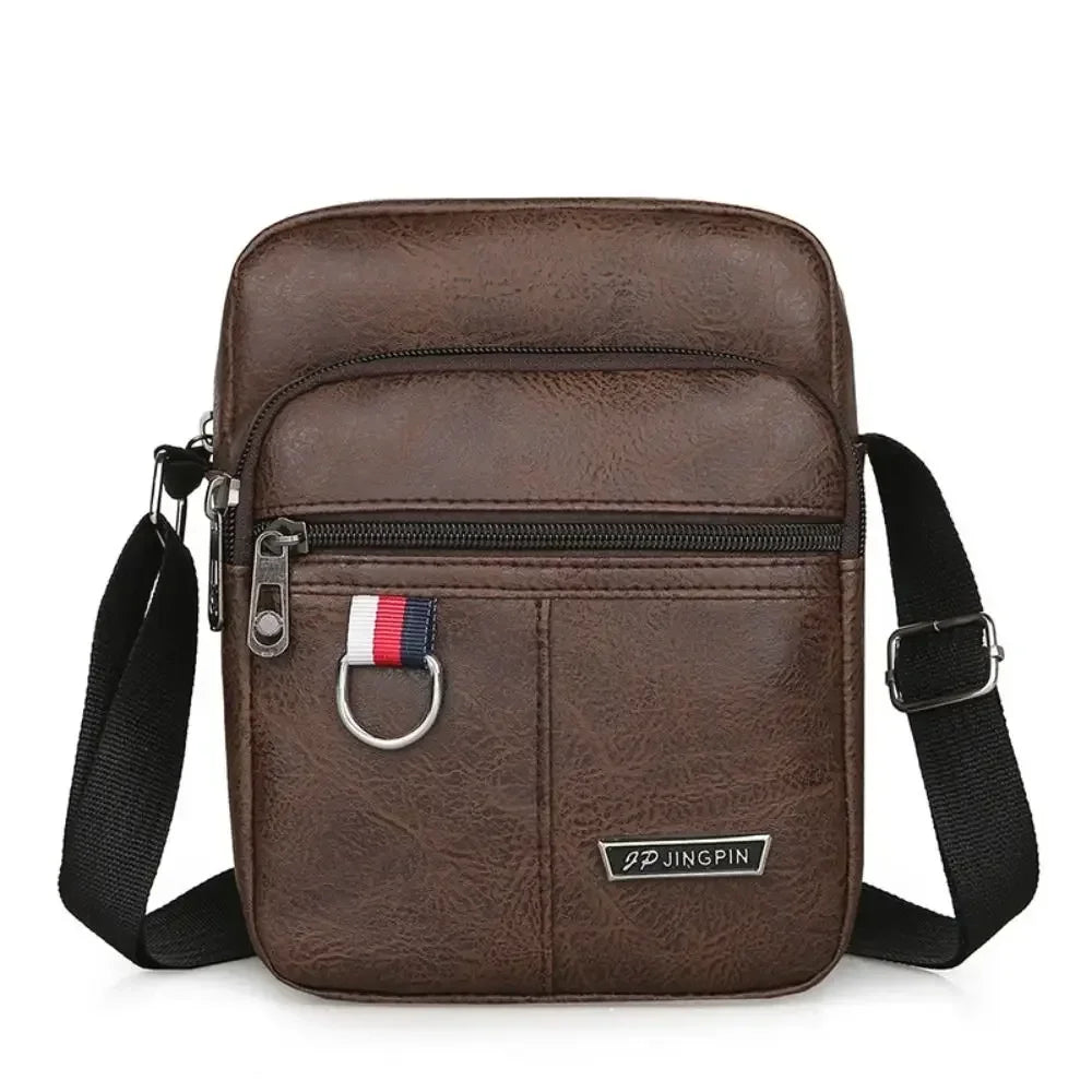 Sac bandoulière marron pour homme avec sangle noire et quincaillerie argentée.