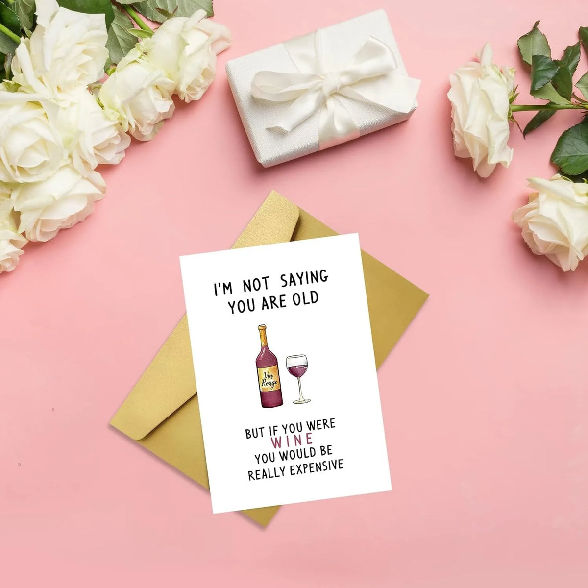 A humorous birthday card for dad featuring text about wine and being old, set against a pink background with roses and a whit