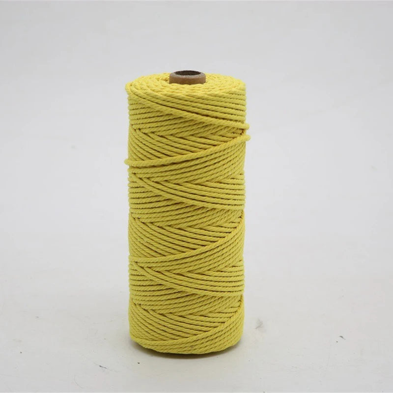 A spool of yellow macrame cord, 3mm/4mm thickness, used for crafting.