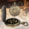 A vintage metal dice case with a dragon motif and a chain, open to reveal seven metal polyhedral dice.