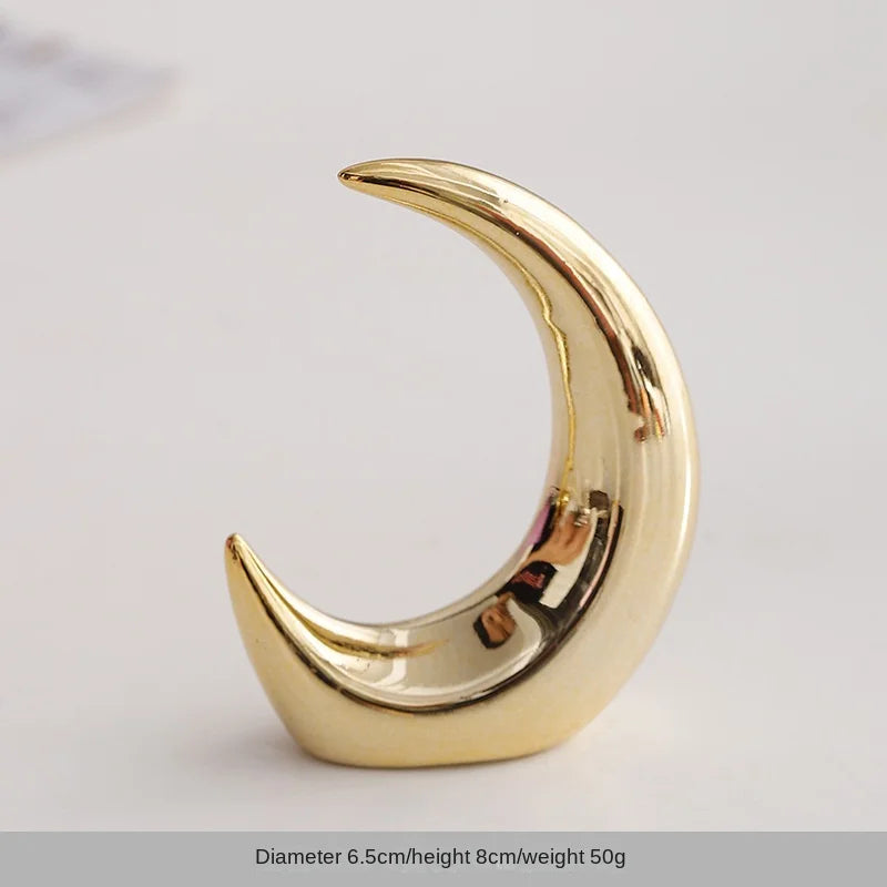 Gold-colored ceramic crescent shaped jewelry holder or desk ornament.