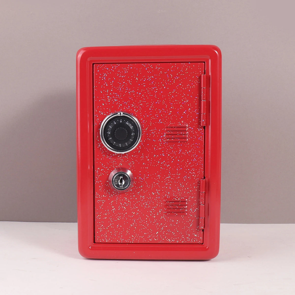 A red vintage metal piggy bank with a combination lock and key.