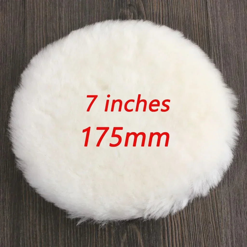A white, fluffy wool polishing pad is shown on a dark wooden surface.
