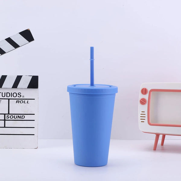 Un vaso (tumbler) de acrílico azul con una pajita junto a una cinta métrica y un pequeño dispositivo electrónico blanco.