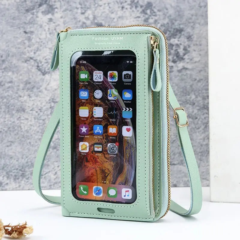 A light mint green hands-free crossbody phone bag with a clear window showing a smartphone interface.