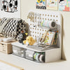 A white desk organizer featuring a grid of transparent drawers and decorative elements like a stuffed animal and various stat