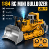 A yellow 1:64 RC mini bulldozer with a blade and tracks is shown on a dark surface.