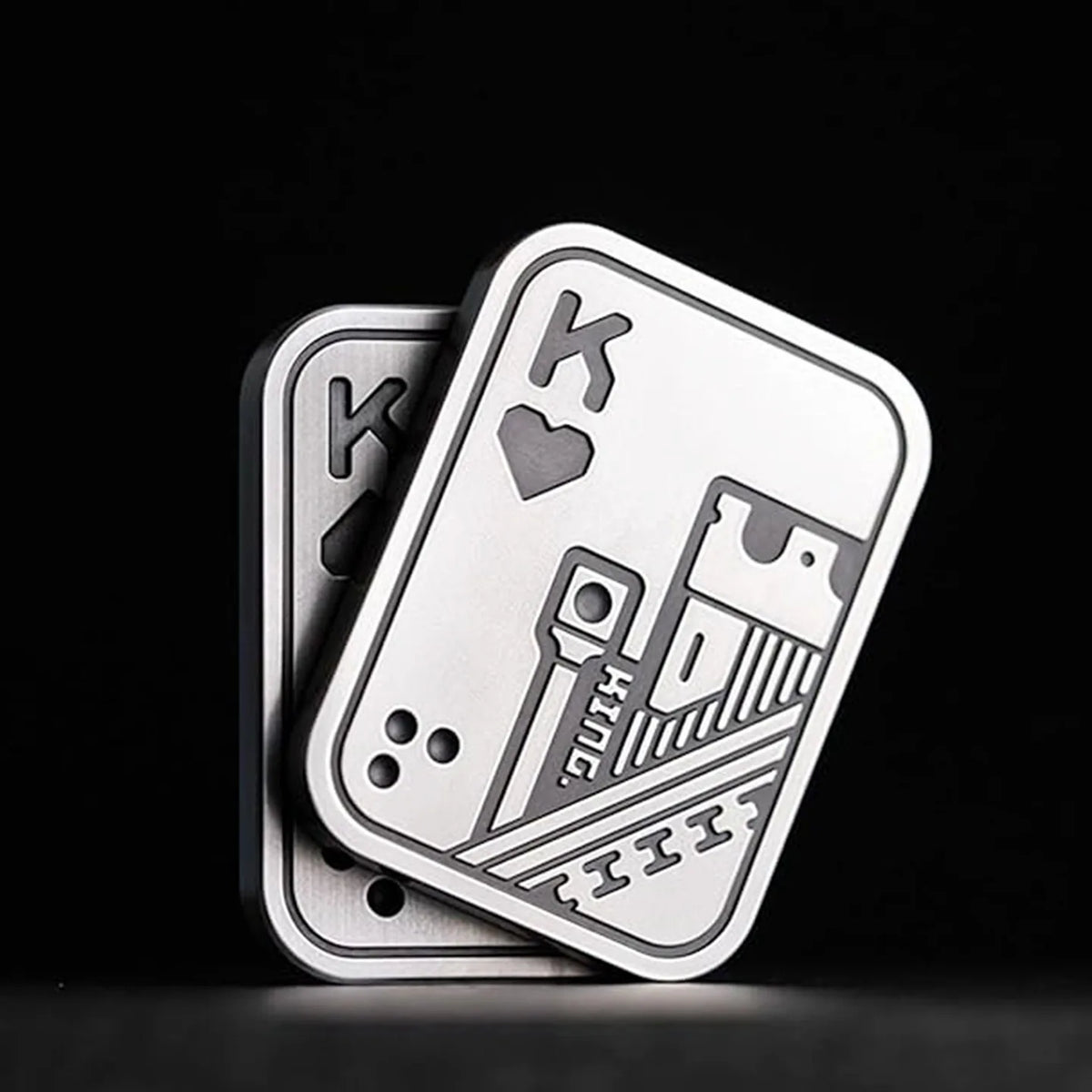 A silver metal poker card featuring a King of hearts and a King of diamonds design.